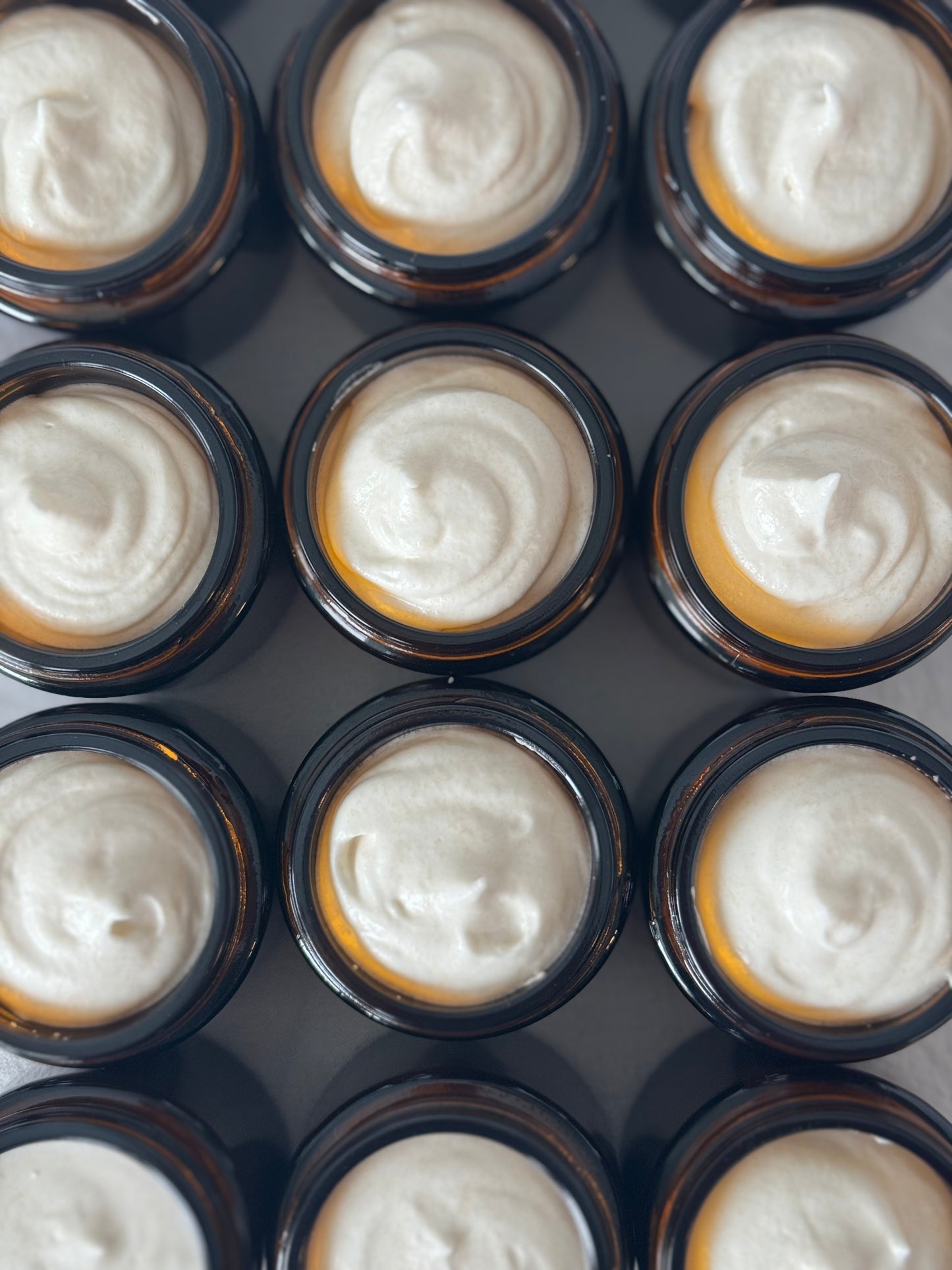 Whipped cloud cream, tallow honey balm, top view filled jars